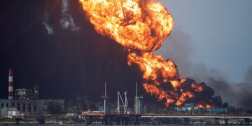 Fire is seen over fuel storage tanks that exploded near Cuba's supertanker port in Matanzas, Cuba, August 8, 2022. REUTERS/Alexandre Meneghini