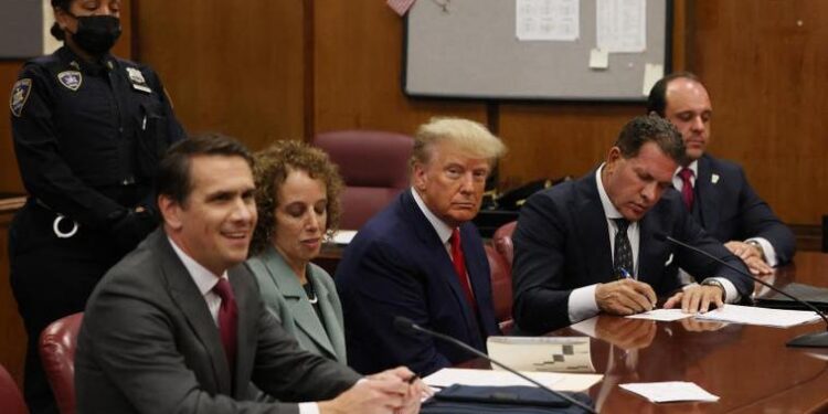 Former U.S. President Donald Trump appears in court with members of his legal team for an arraignment on charges stemming from his indictment by a Manhattan grand jury following a probe into hush money paid to porn star Stormy Daniels, in New York City, U.S., April 4, 2023. REUTERS/Andrew Kelly/Pool
