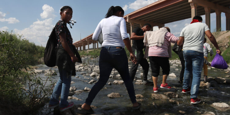 A group of migrants crosses the Rio Grande from Ciudad Juárez, Mexico into the United States, on Sept. 12, 2022. Most migrants are from Venezuela and turn to the Border Patrol in El Paso, Texas.