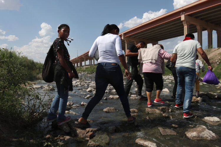 A group of migrants crosses the Rio Grande from Ciudad Juárez, Mexico into the United States, on Sept. 12, 2022. Most migrants are from Venezuela and turn to the Border Patrol in El Paso, Texas.