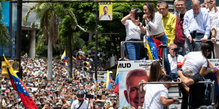AME6591. CARACAS (VENEZUELA), 30/07/2024.- La líder opositora venezolana María Corina Machado (i) habla junto al candidato a la presidencia de Venezuela Edmundo González Urrutia (d) este martes, en Caracas (Venezuela). Miles de venezolanos se han concentrado este martes en Caracas, en un acto convocado por la oposición mayoritaria, para rechazar por segundo día consecutivo lo que consideran es un fraude en los resultados oficiales del Consejo Nacional Electoral (CNE), que en la víspera proclamó a Nicolás Maduro como presidente reelecto con el 51,2 % de los votos. EFE/ Ronald Peña R.